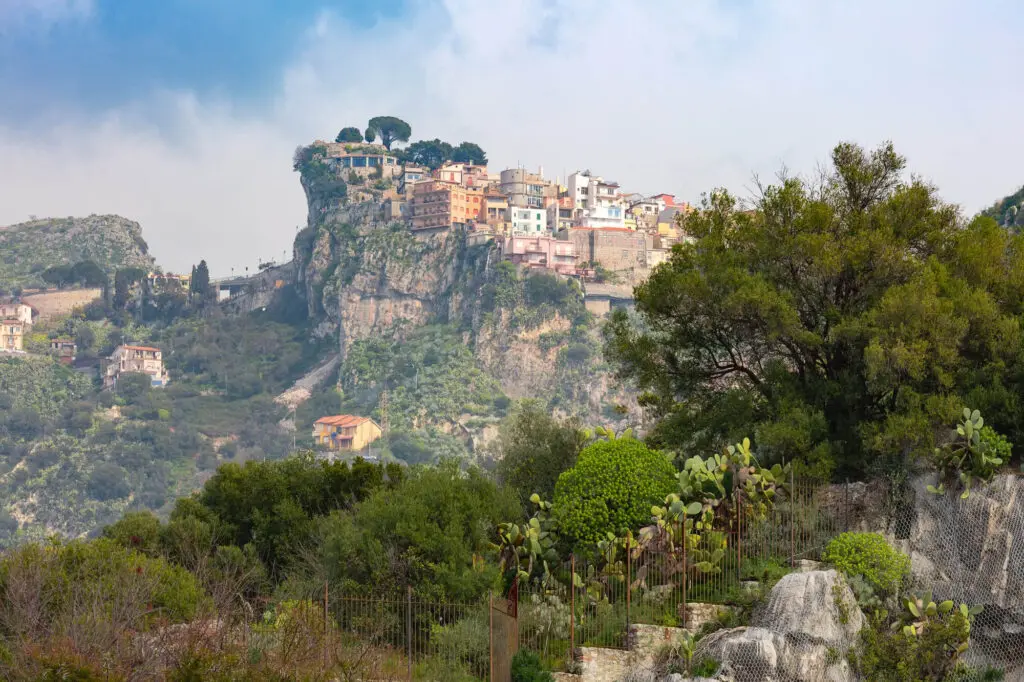 Villaggio arroccato su scogliera, vegetazione mediterranea.
