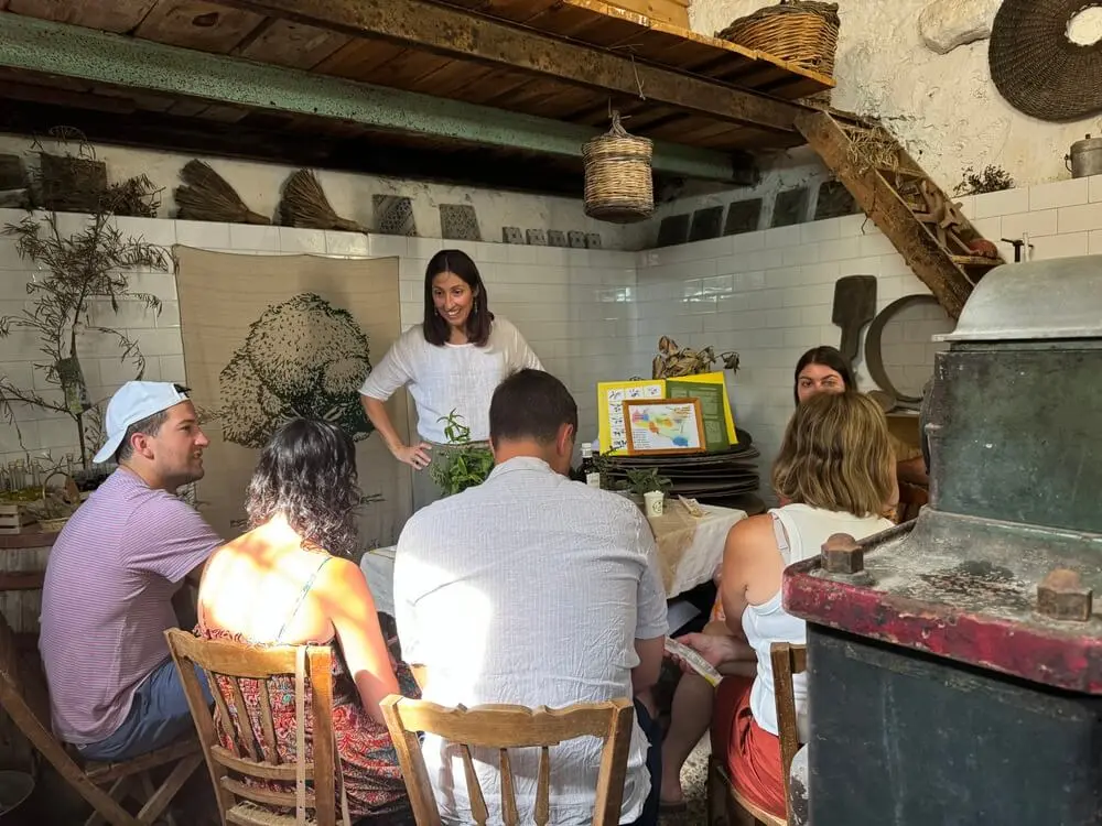 Gruppo attento ascolta lezione in ambiente rustico.