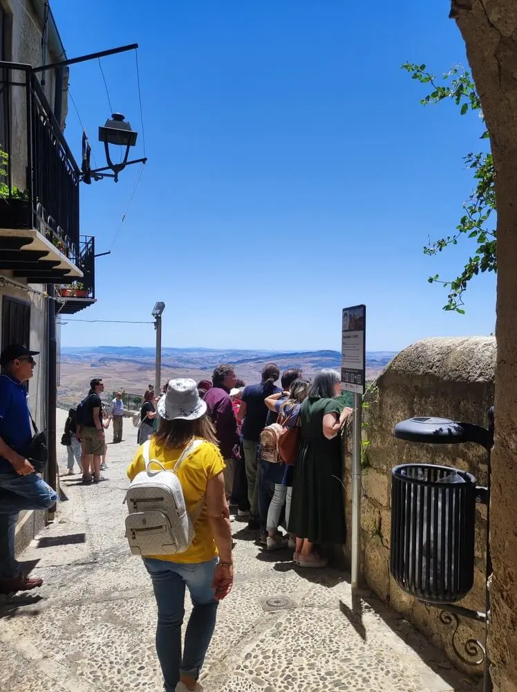 Gruppo di persone ammira panorama, borgo antico.
