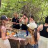 Gruppo di donne prepara cibo all'aperto, bosco.