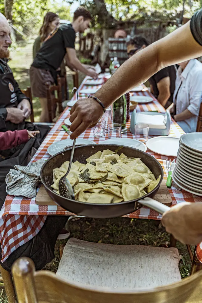 Ravioli al burro e salvia serviti in una padella, in un giardino.